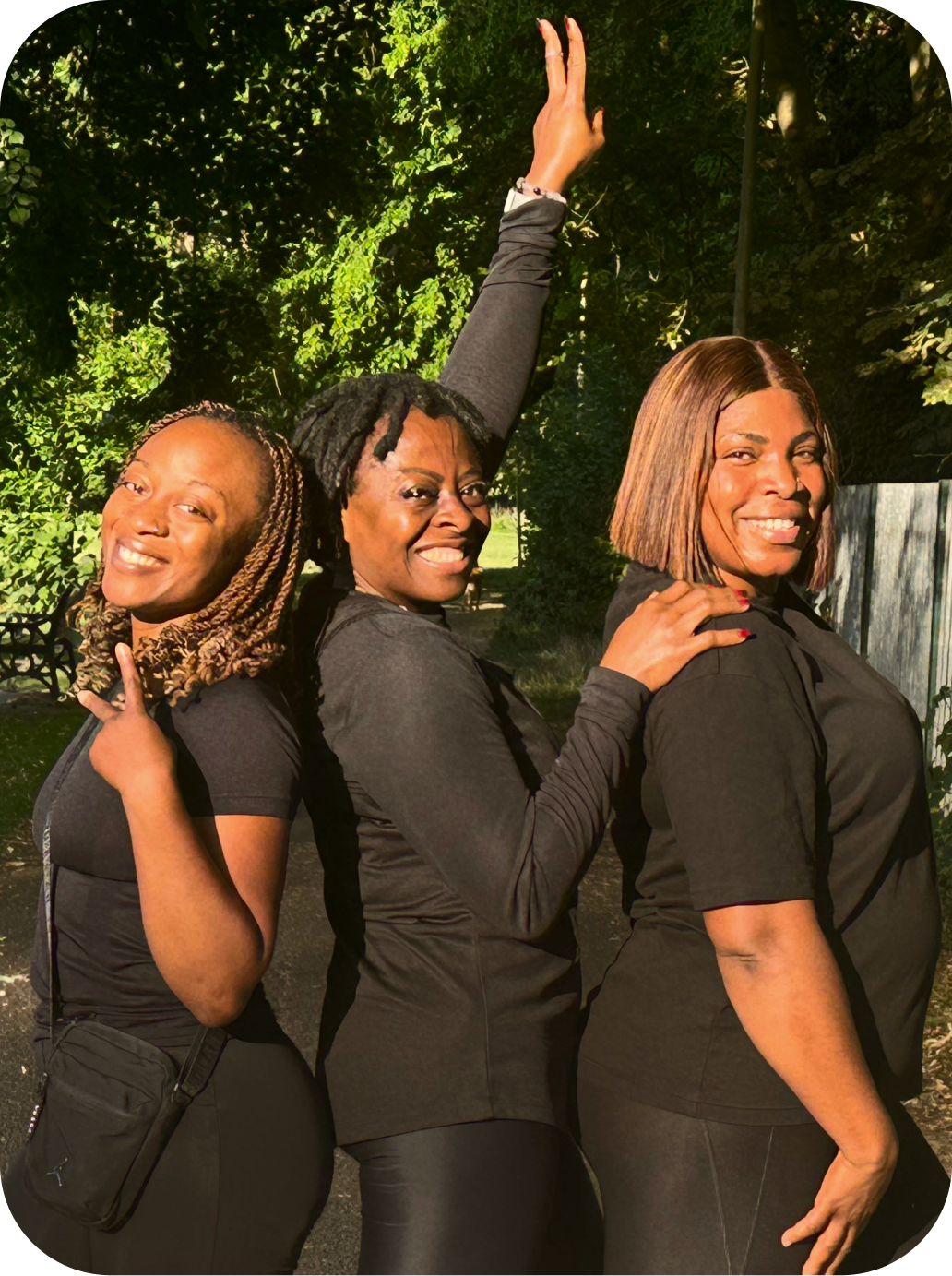 Three women in black workout attire laughing together